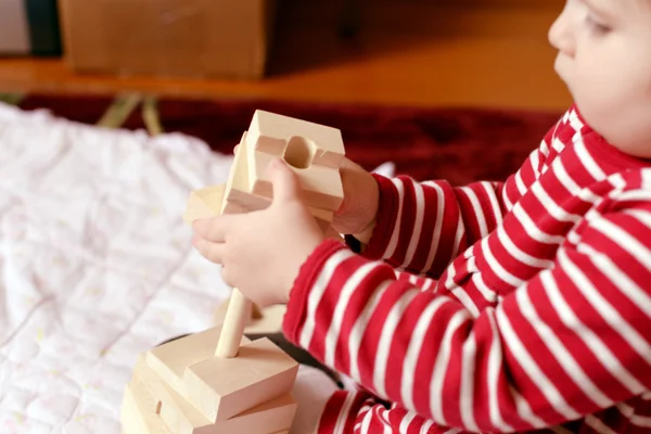 Baby spielt mit einfachem Holzspielzeug Stockfoto