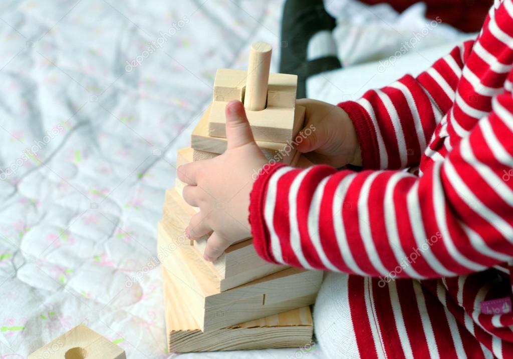 Baby playing with simple wooden toys