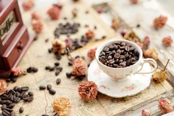 Granos de café y rosas secas esparcidas por el viejo mapa — Foto de Stock