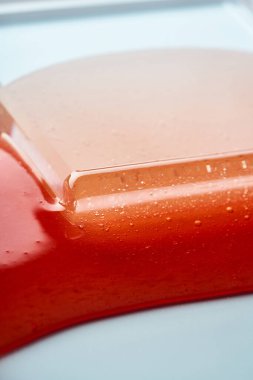 Kırmızı şeffaf kozmetik jelin dokusu. Soyut arkaplan