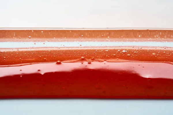 透明感のある赤い化粧品ジェルの質感 要旨の背景 — ストック写真