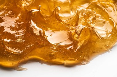 Beyaz arka planda şeffaf sarı yüz kremi ya da altın bal lekesi. Beyaz arkaplanda altın kremalı doku.