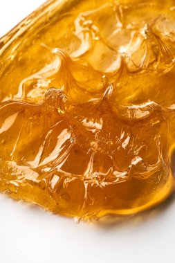 Beyaz arka planda şeffaf sarı yüz kremi ya da altın bal lekesi. Beyaz arkaplanda altın kremalı doku.