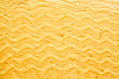 Beyaz arka planda şeffaf sarı yüz kremi ya da altın bal lekesi. Beyaz arkaplanda altın kremalı doku.