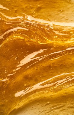 Beyaz arka planda şeffaf sarı yüz kremi ya da altın bal lekesi. Beyaz arkaplanda altın kremalı doku.