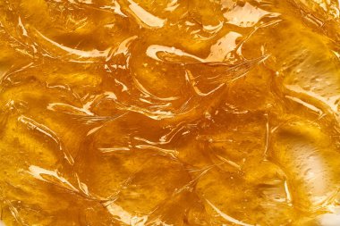 Beyaz arka planda şeffaf sarı yüz kremi ya da altın bal lekesi. Beyaz arkaplanda altın kremalı doku.