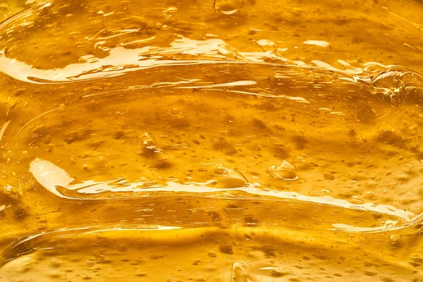 白い背景に隔離された顔クリームや黄金の蜂蜜の透明黄色のスミア 白い背景の黄金のクリーミーなテクスチャ — ストック写真