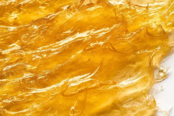 白い背景に隔離された顔クリームや黄金の蜂蜜の透明黄色のスミア 白い背景の黄金のクリーミーなテクスチャ — ストック写真