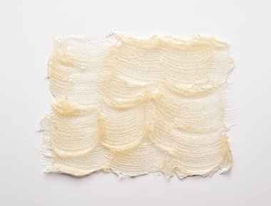 Beyaz arka planda altın kozmetik jelin şeffaf lekesi ve dokusu.