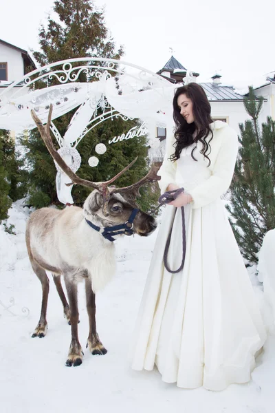 Mooie bruid in een vacht cape met rendieren — Stockfoto