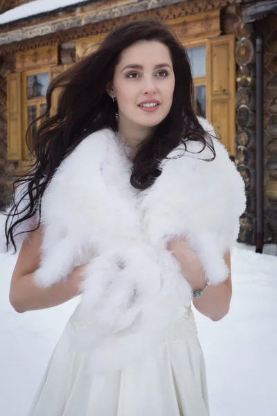 Panna młoda w pelerynie futro w wioska zima śnieg — Zdjęcie stockowe