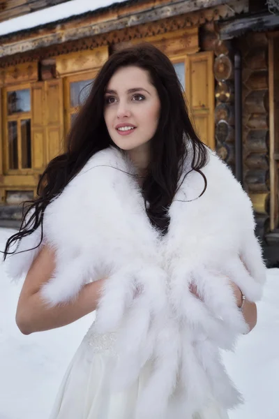 Panna młoda w pelerynie futro w wioska zima śnieg — Zdjęcie stockowe