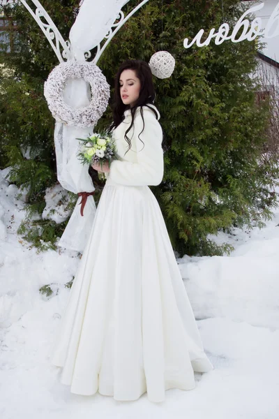 Belle mariée en cape de fourrure avec un bouquet — Photo