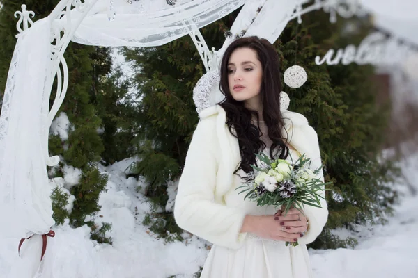 Όμορφη νύφη σε ένα ακρωτήριο γούνα με ένα μπουκέτο — Φωτογραφία Αρχείου