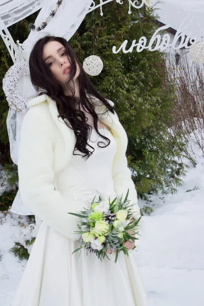 Belle mariée en cape de fourrure avec un bouquet — Photo