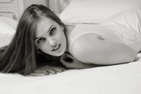 Сексуальна емоційна приваблива молода жінка лежить на ліжку в спальні . — стокове фото