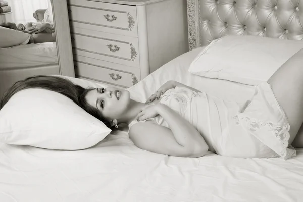 Sexual emotional attractive young woman lying on bed in bedroom. — Stock Photo, Image