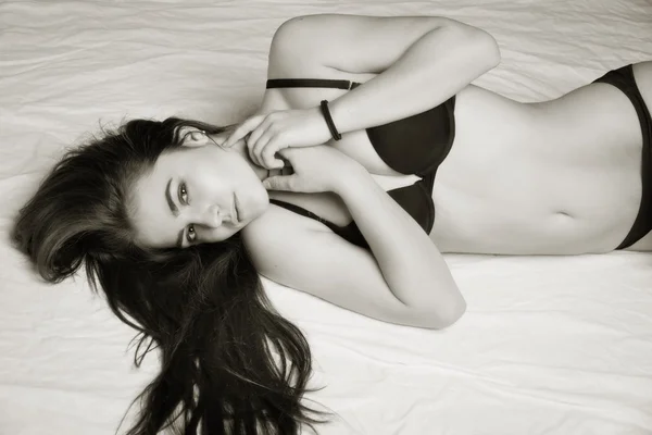 Αισθησιασμό σέξι γυναίκα με ένα τέλειο σώμα, ξαπλωμένη στο κρεβάτι — Φωτογραφία Αρχείου