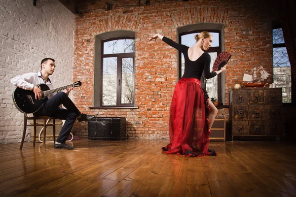 Mujer joven bailando flamenco y un hombre tocando la guitarra — Foto de Stock