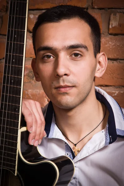 Hispánský muž hospodářství akustická kytara — Stock fotografie