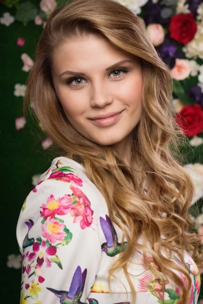 Schöne Sinnlichkeit Mädchen auf einer Blumenmauer Hintergrund — Stockfoto