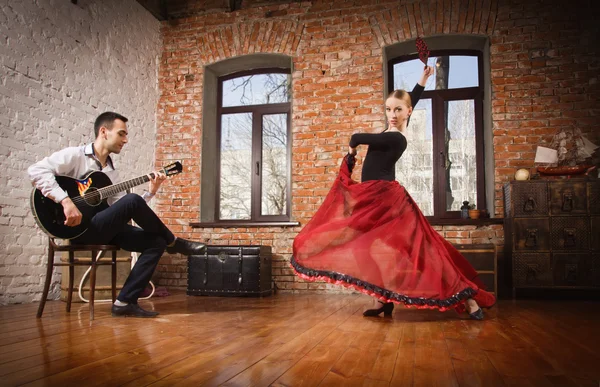 En ung kvinne som danser flamenco og en mann som spiller gitar – stockfoto
