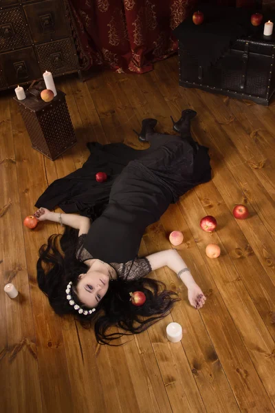 Жінка з отруєним яблуком лежить на підлозі — стокове фото