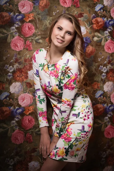 Чувственная девушка на фоне цветочной стены — стоковое фото