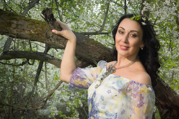 Mujer adulta elegante posando en el jardín de primavera — Foto de Stock