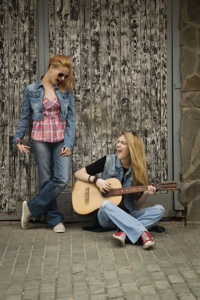 Hippie vackra flicka vänner spelar gitarr i staden — Stockfoto