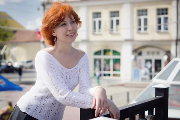 Schöne rothaarige Frau zu Fuß auf der europäischen Straße — Stockfoto