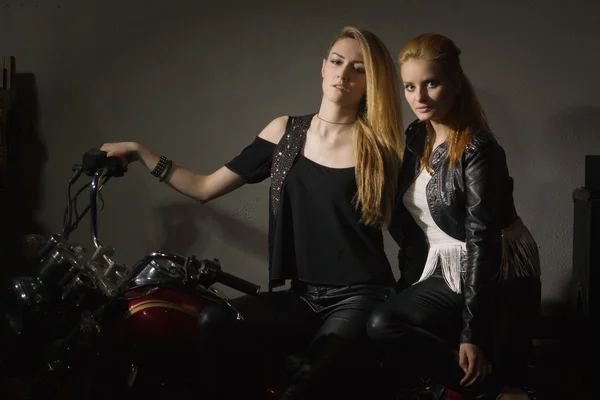 Dos hermosas amigas rockeras en el club de rock con motocicleta — Foto de Stock