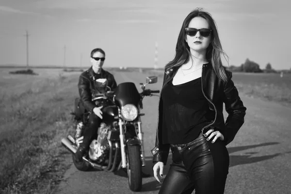 Biker man and girl stands on the road — Stock Photo, Image