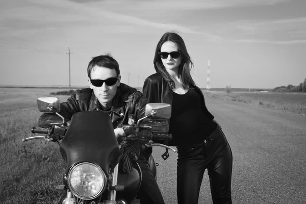 Motociclista hombre y chica se para en el camino — Foto de Stock