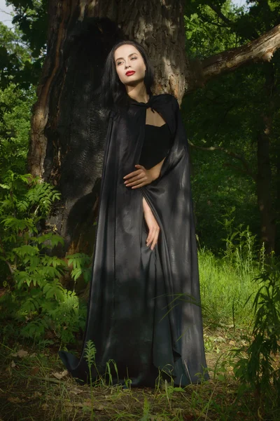 검은 드레스와 검은 망 토는 m에서 아름 다운 갈색 머리 여자 — 스톡 사진