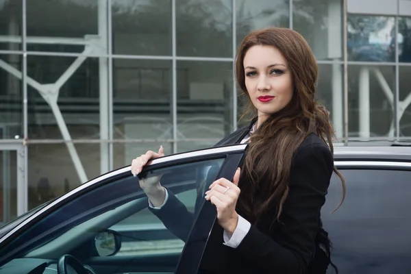 Zakenvrouw die permanent in de achtergrond van de straat-auto — Stockfoto