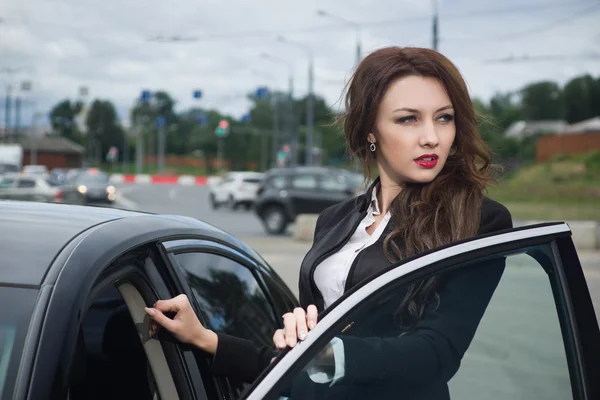 Zakenvrouw die permanent in de achtergrond van de straat-auto — Stockfoto