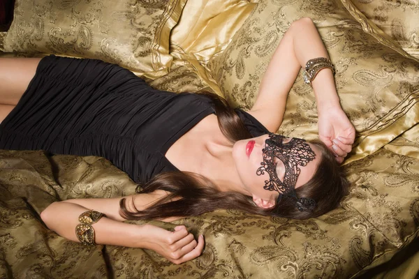 时尚性感的深色女人在卧室穿黑色的连衣裙和面具 — 图库照片