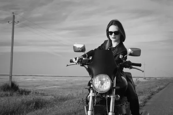 Chica motorista en una chaqueta de cuero en una motocicleta —  Fotos de Stock