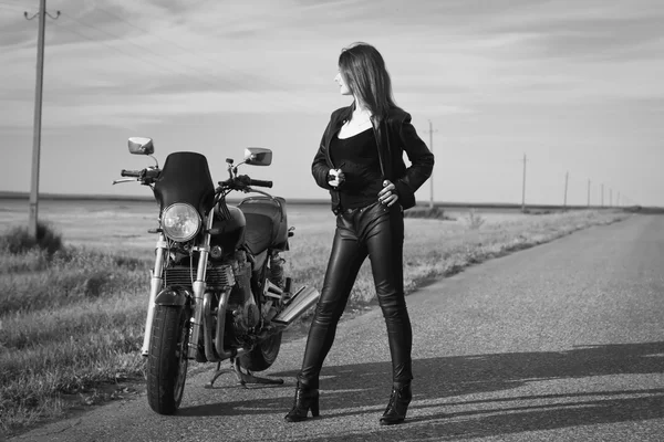 Biker fille dans une veste en cuir posant près de la moto — Photo