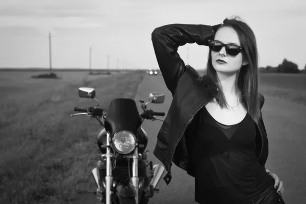 Kostým motorkářka v kožené bundě, pózuje u motocyklu — Stock fotografie