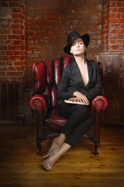 Elegante modieuze vrouw zwart pak en hoed dragen in een vintag — Stockfoto