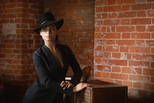 Elegante mujer de moda con traje negro y sombrero en un vinagre —  Fotos de Stock
