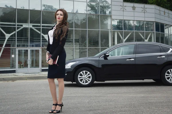 Geschäftsfrau steht auf der Straße im Hintergrund Auto — Stockfoto