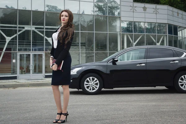 Mujer de negocios de pie en la calle coche de fondo — Foto de Stock