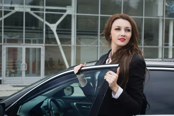 Mujer de negocios de pie en la calle coche de fondo —  Fotos de Stock