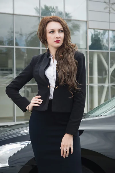 Mujer de negocios de pie en la calle coche de fondo — Foto de Stock