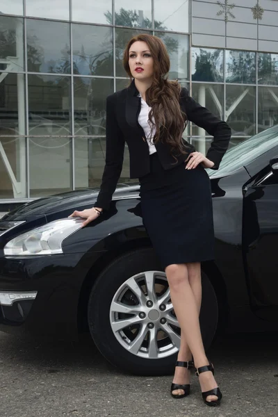 Mujer de negocios de pie en la calle coche de fondo — Foto de Stock