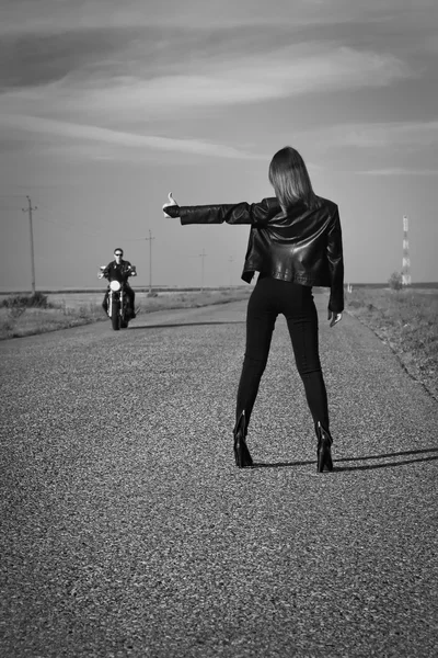 Girl votes hitchhiking on a road — Stock Photo, Image