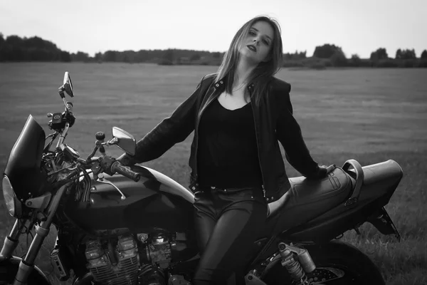 Chica motorista en una chaqueta de cuero en una motocicleta — Foto de Stock